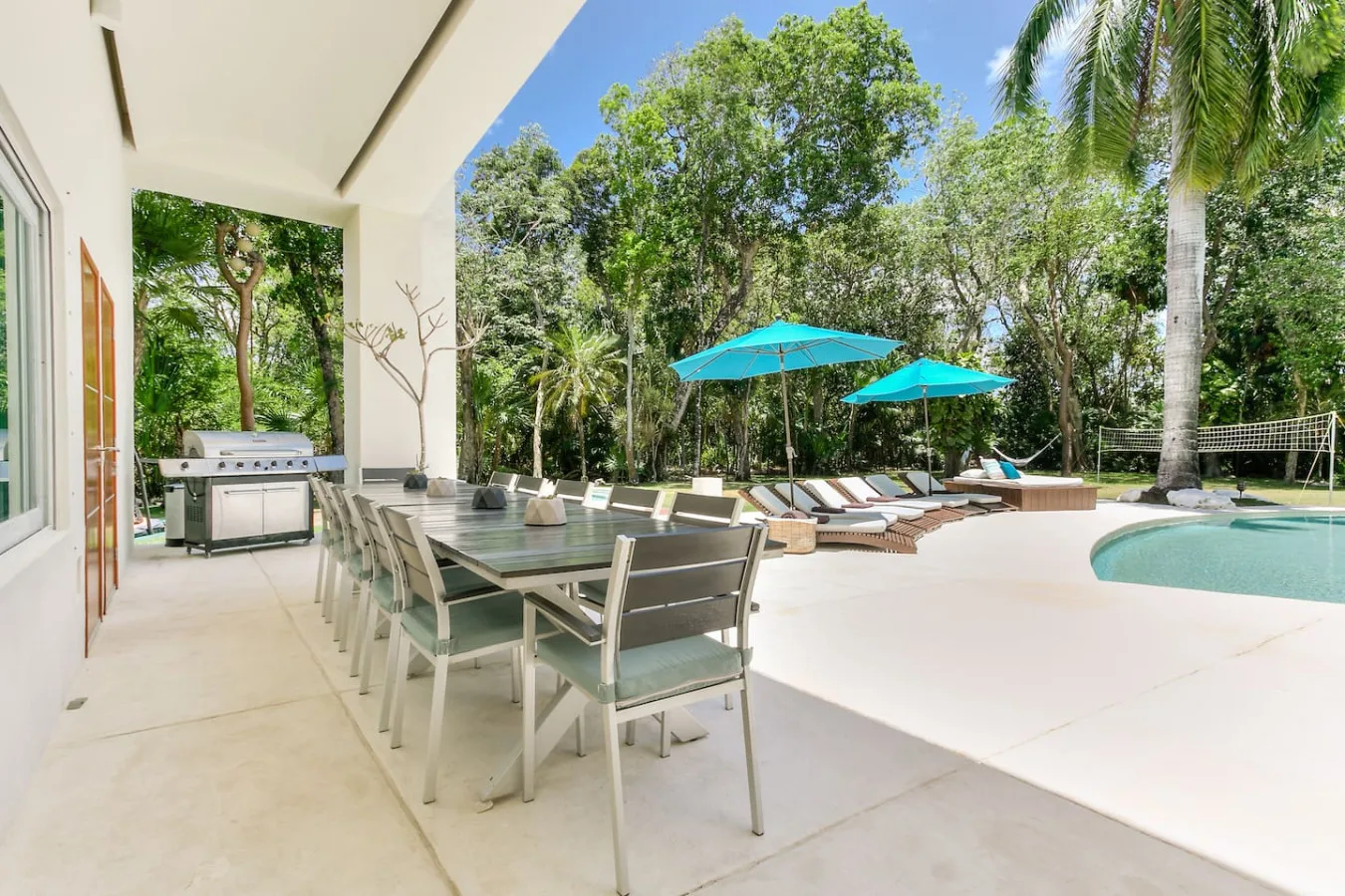 Golden hour light through the palms over Villa Aqua's pool deck